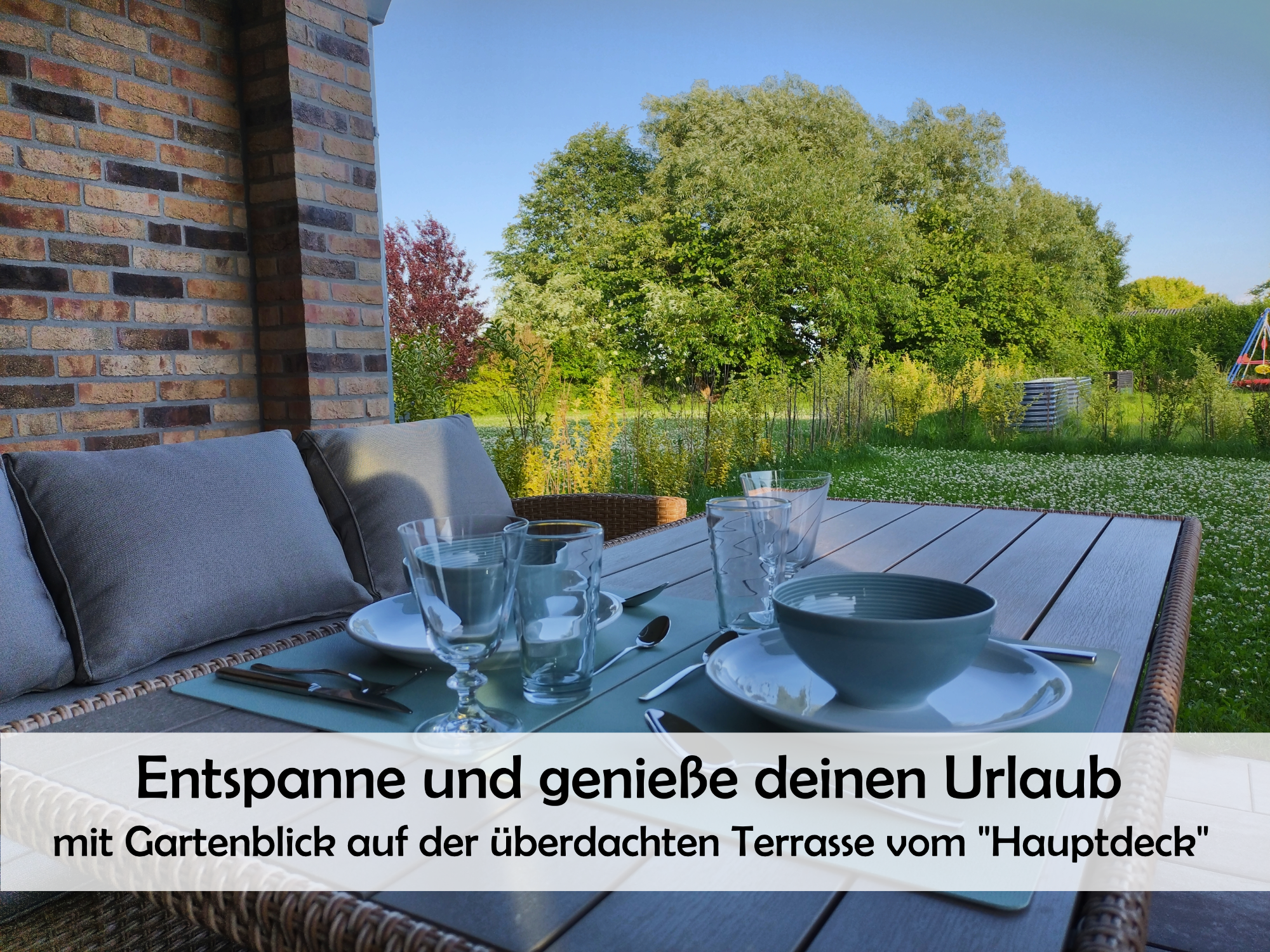Blick von der überdachten Terrasse in den Garten